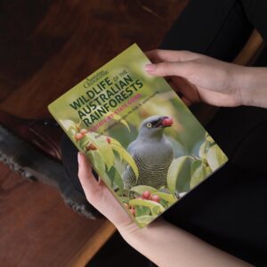 Hands holding a copy of the Wildlife of the Australian Rainforests book