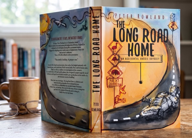 The Long Road Home book standing on a table with other books in the background